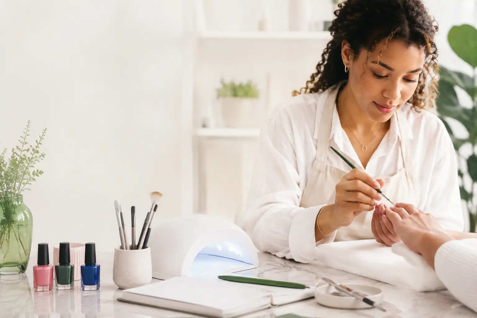 Professional nail artist creating a manicure in a bright studio
