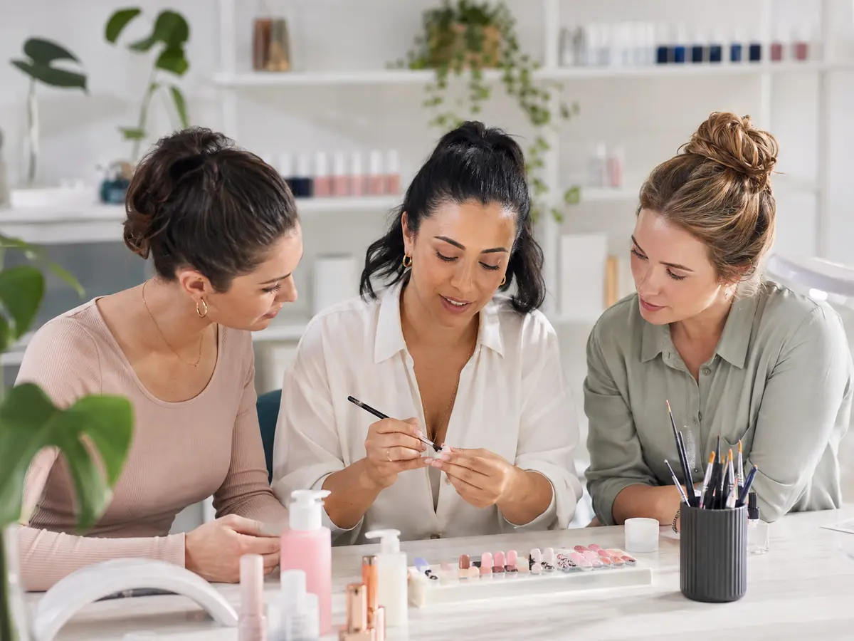 Nail educator teaching professional nail art techniques to adult students